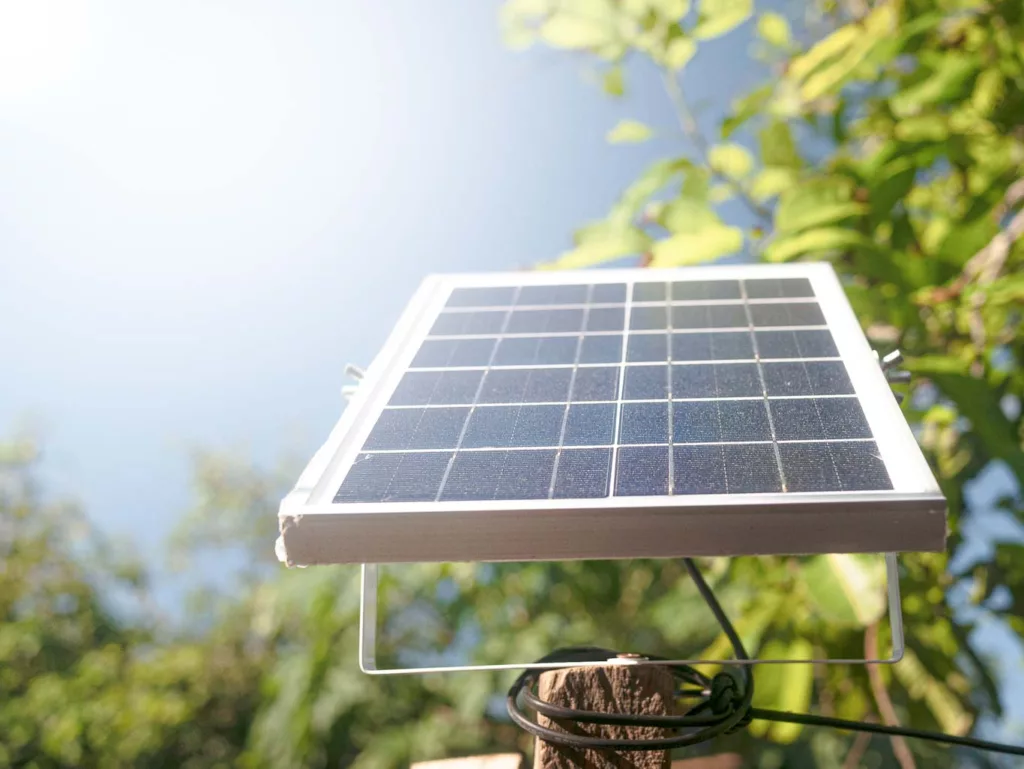 Small solar panels set on outdoor poles on a dog house. Find out more at doghousetimes.com.
